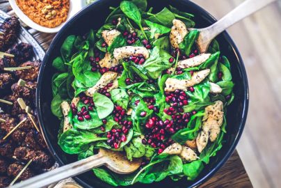 Healthy and vibrant spinach salad with grilled chicken and pomegranate seeds, perfect for a nutritious meal.