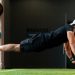 Middle Eastern man doing explosive pushups on gym turf.